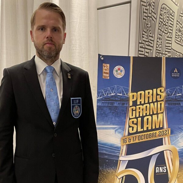 Björn Nyberg i svart kostym framför en roll-up för Paris Grand Slam.