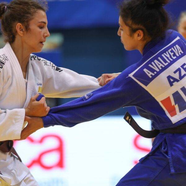 Tara Babulfath i vit judodräkt och brunt bälte greppar sin motståndares judodräkt på tävling.