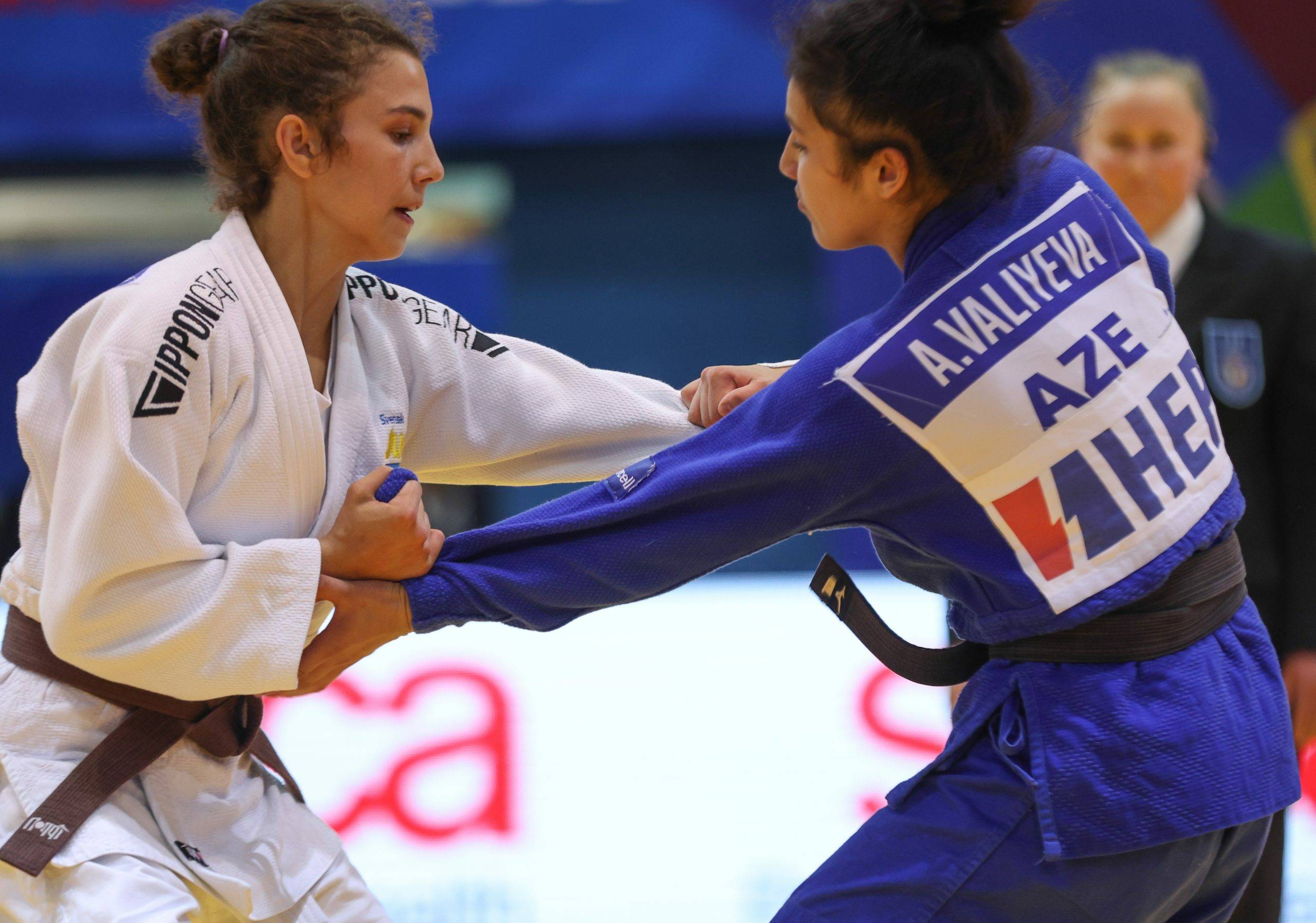 Tara Babulfath i vit judodräkt och brunt bälte greppar sin motståndares judodräkt på tävling.