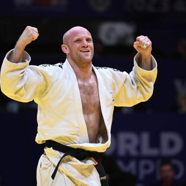 Marcus Nyman i vit judodräkt höjer knutna nävar i segergest.
