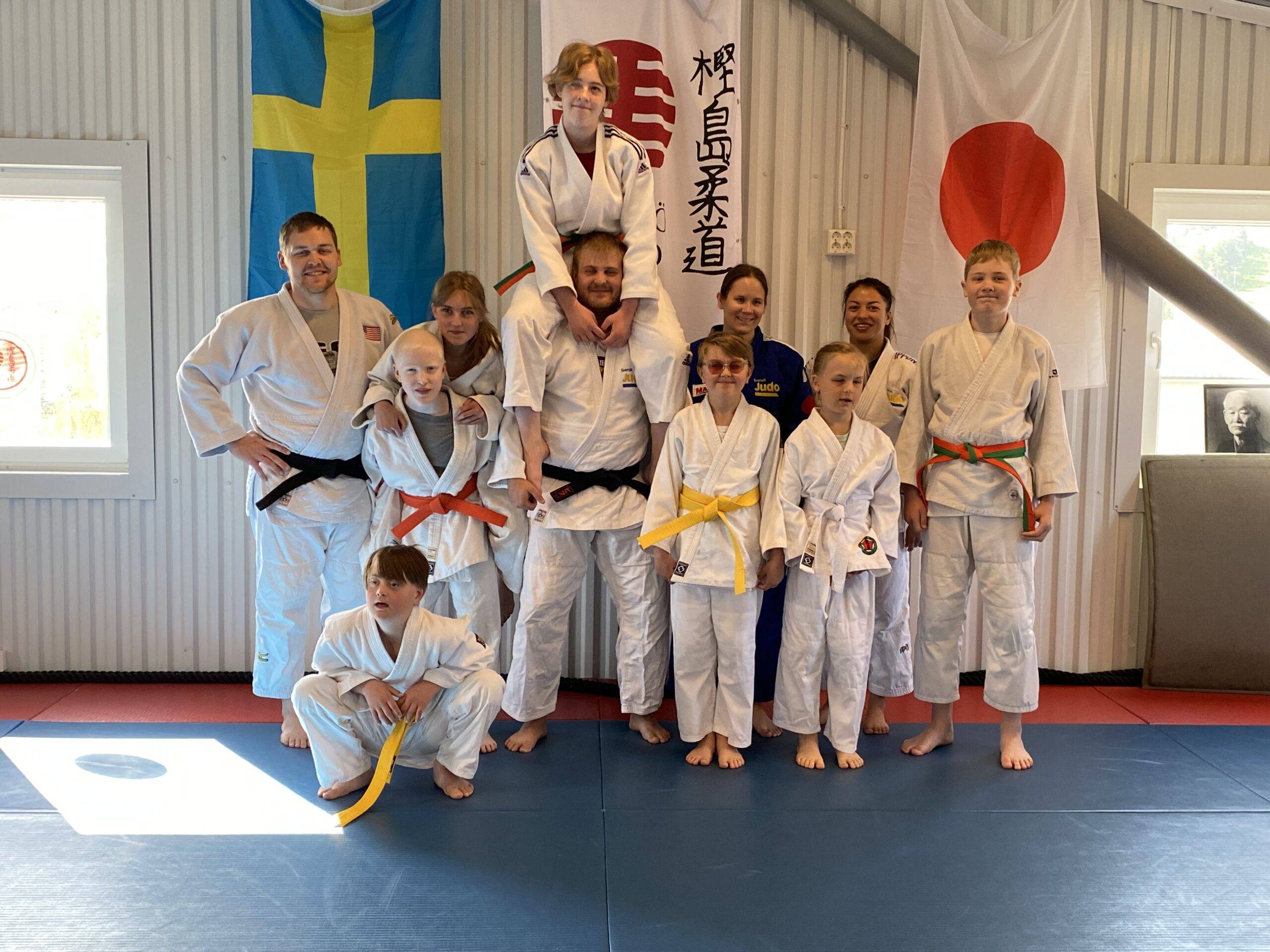 Barn- ungdomar och tränare i judodräkter.