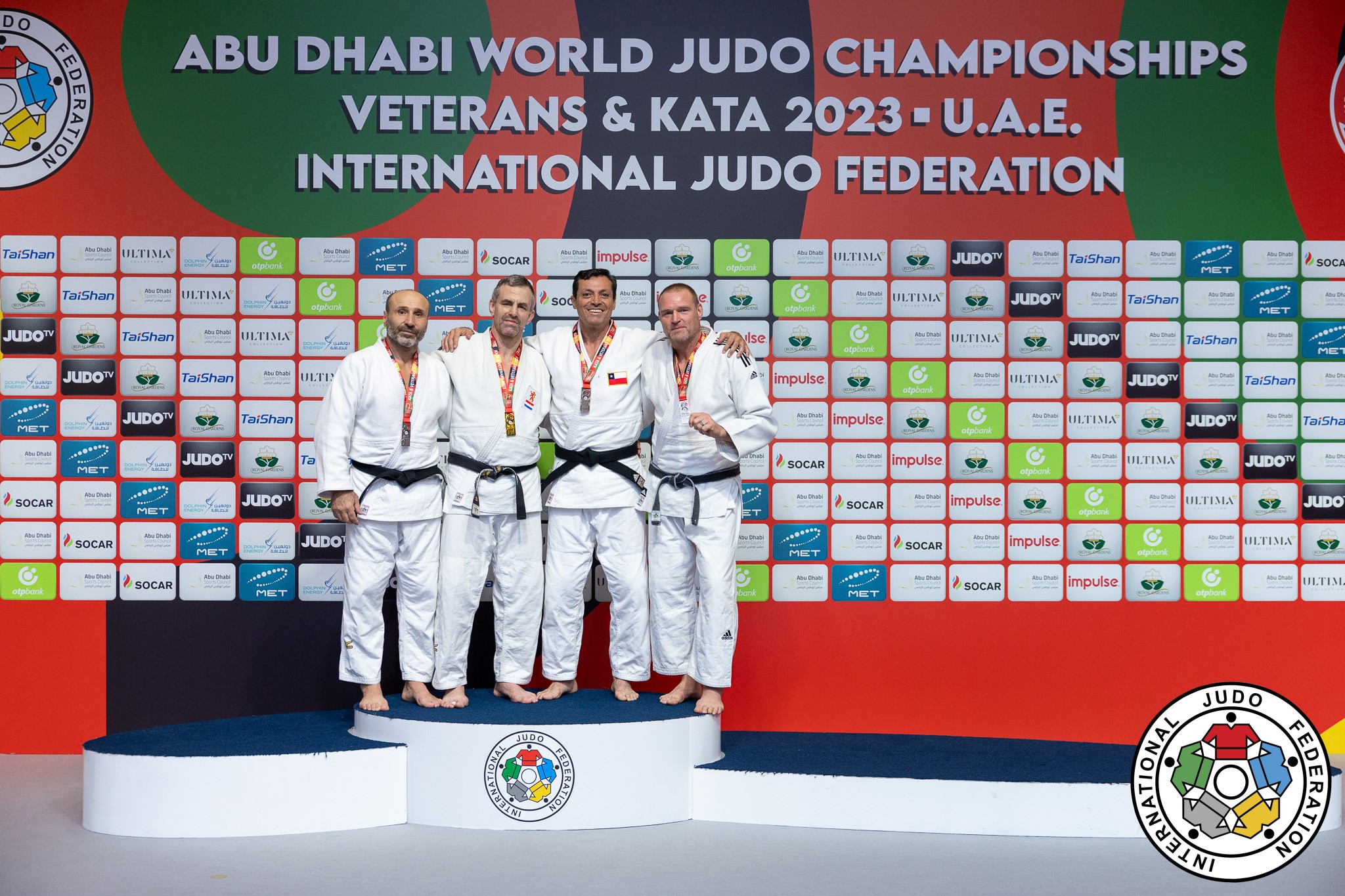 Karl Baker i vit judodräkt står på prispallen.